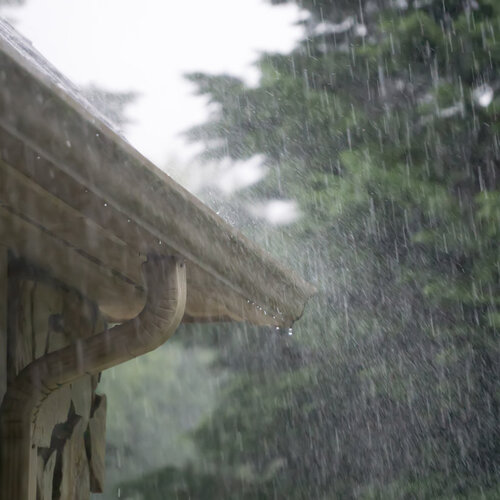 close-up of roof and gutters during heavy rainfall