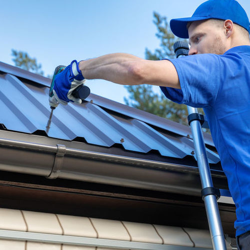 Roofer Works on a Metal Roof