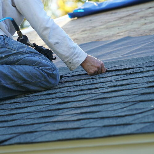 A Roofer Installs Shingles.