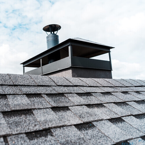 selective focus of modern chimney on rooftop of house