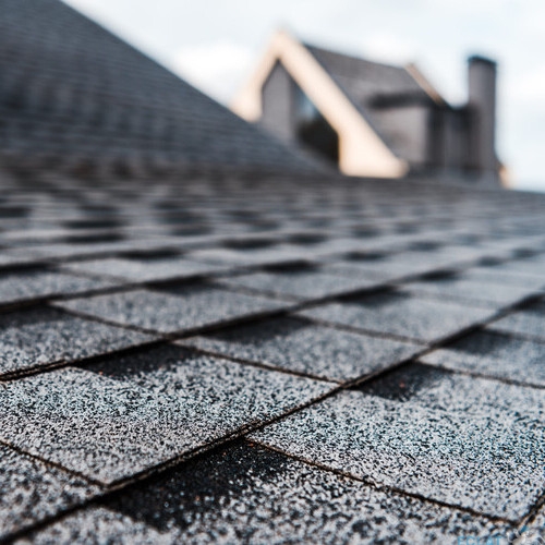 selective focus of grey shingles on rooftop of building