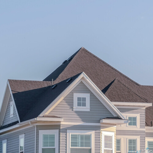 Panorama frame Modern upper floor of a grey timber house with white surrounds on the windows against a blue sky