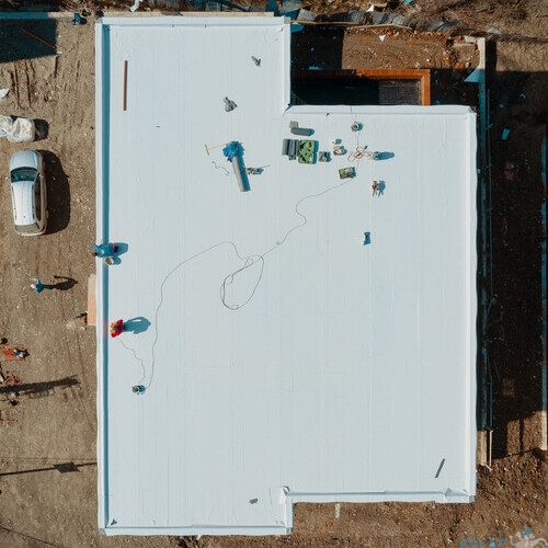 Aerial view of an apartment building with flat roof in construction, ballasted system with geotextile, PVC or EPDM membrane