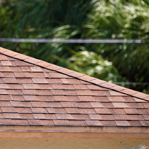 Closeup of house roof top covered with asphalt or bitumen shingles. Waterproofing of new building