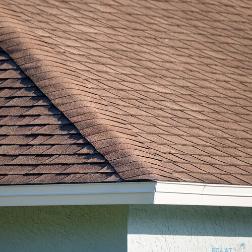Closeup of house roof top covered with asphalt or bitumen shingles. Waterproofing of new building