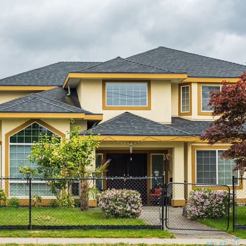 Real Estate Exterior Front House on a sunny day. Big custom made luxury house with asphalt shingle roofing