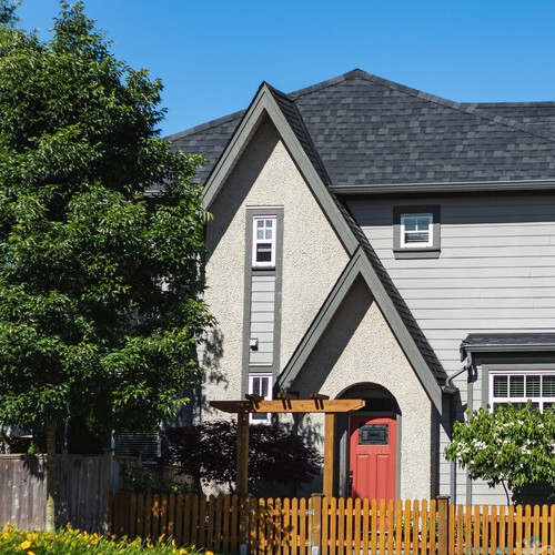Real Estate Exterior Front Houses. Big custom houses with front yard in the comfortable neighborhood on a sunny day. Big luxury home with big windows in the suburbs of North America