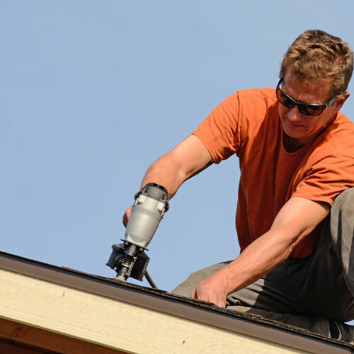 A Roofer Installs New Shingles.