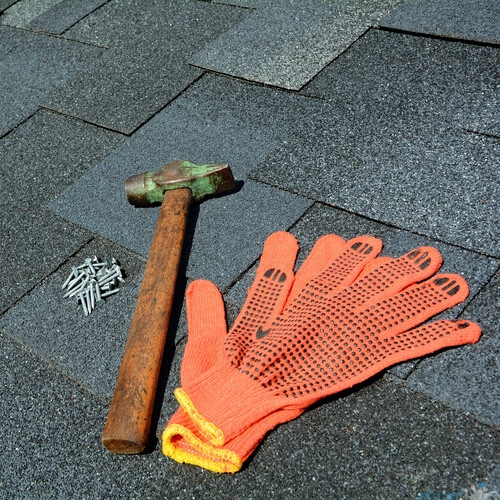 various tools on an asphalt shingle roof