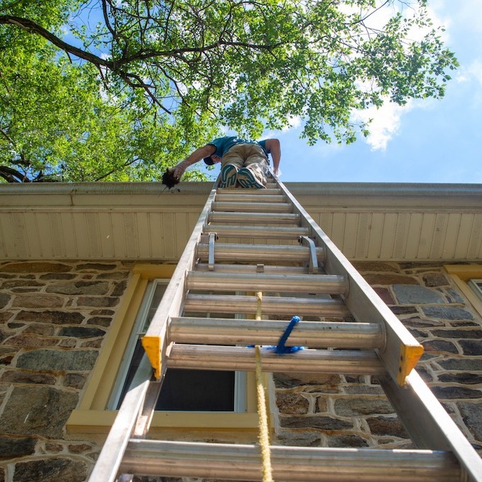 Insurance inspector ascending roof via a ladder